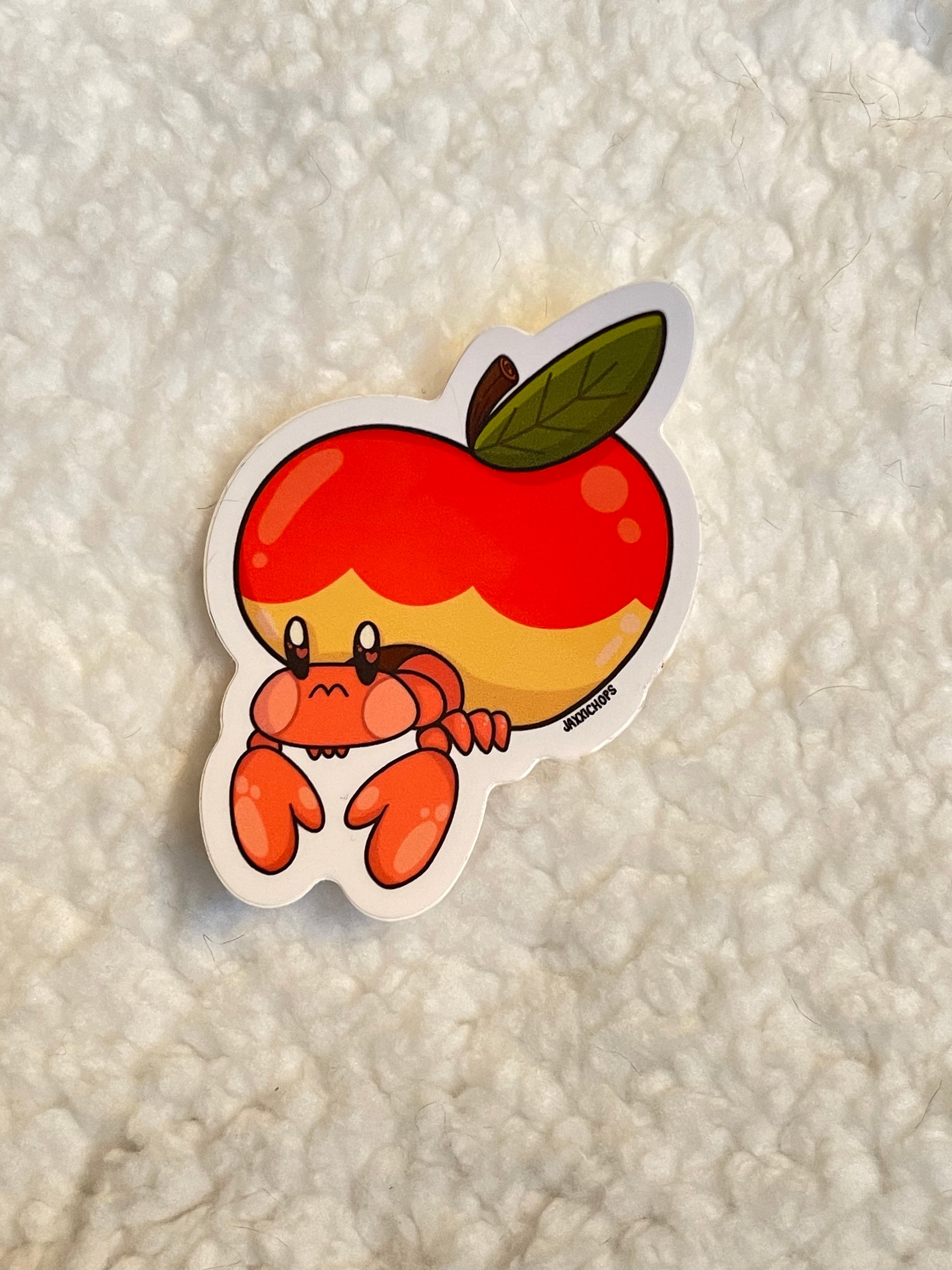 Sticker of a hermit crab inside of an apple, making a crab apple.